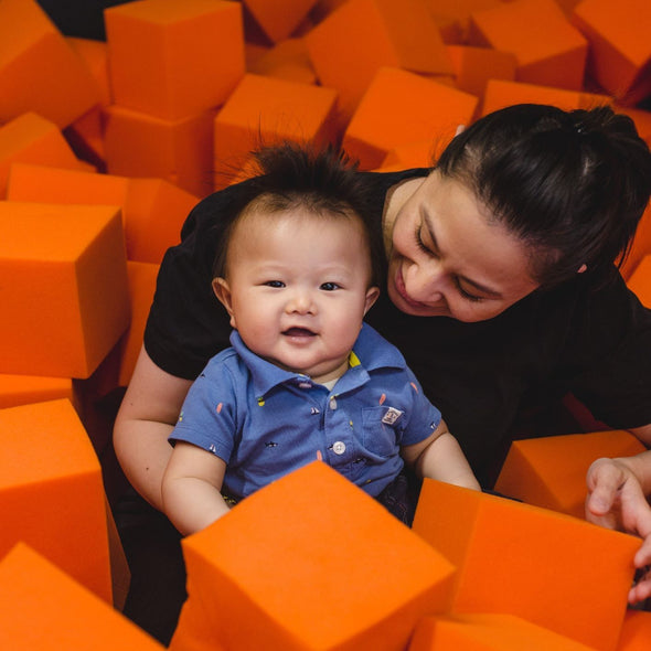 Baby in foam pit with mom